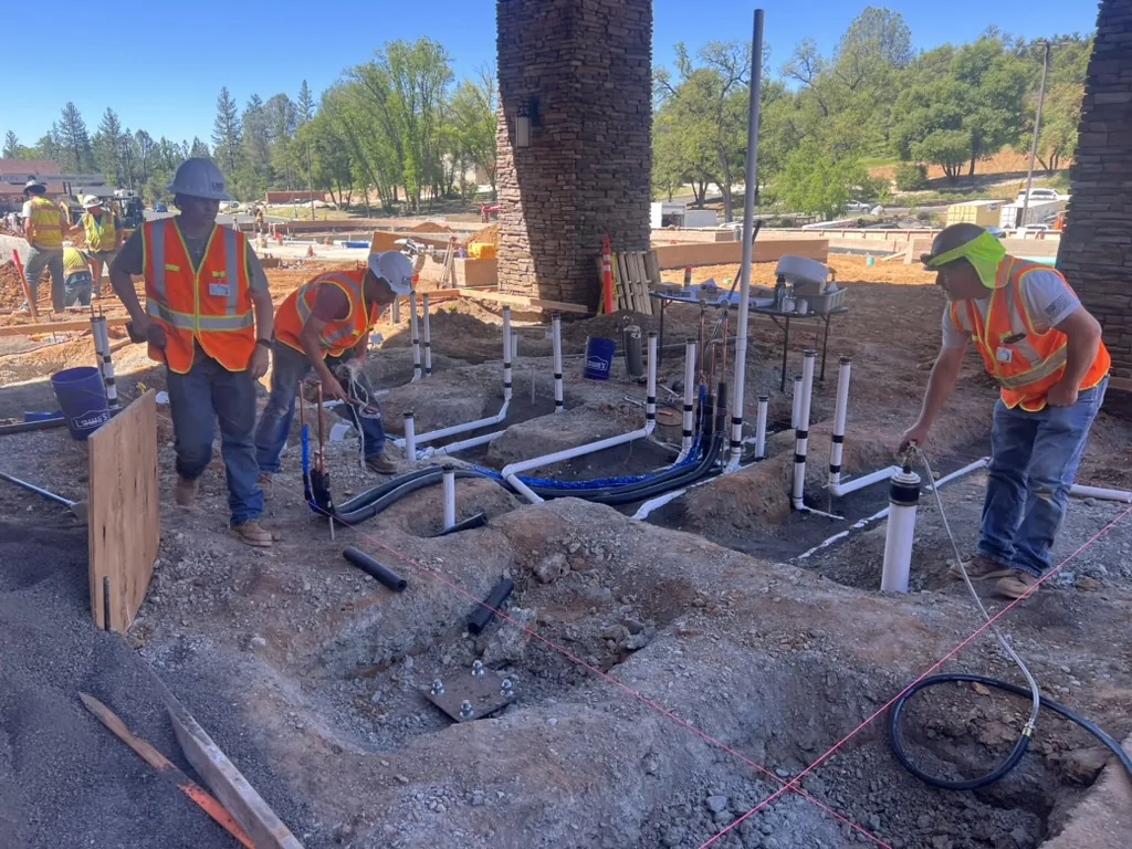 J. Hart crew installing underground plumbing on a commercial job site